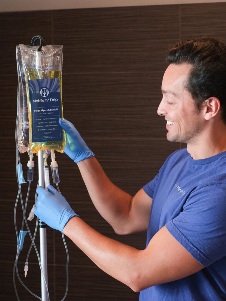 Smiling man holding IV drip bag.