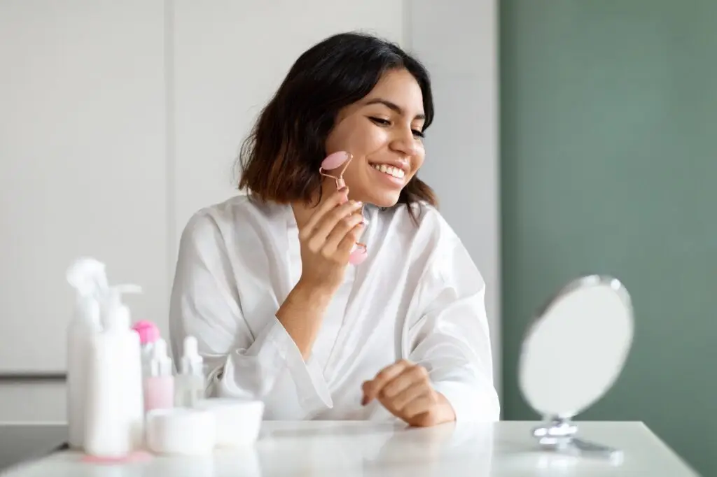 Happy woman using natural stone massager, enjoying healthy glowing skin