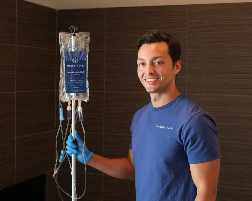 Person holding Mobile IV Drip bag, smiling.