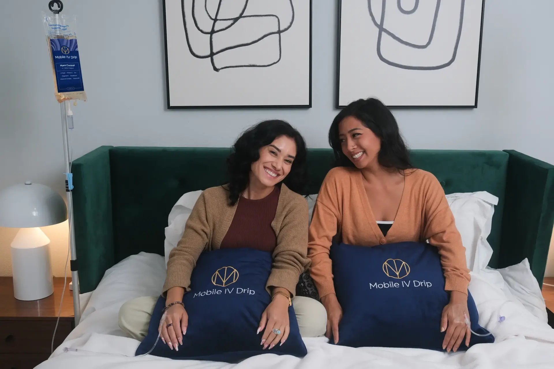 Two women smiling with Mobile IV Drip pillows.