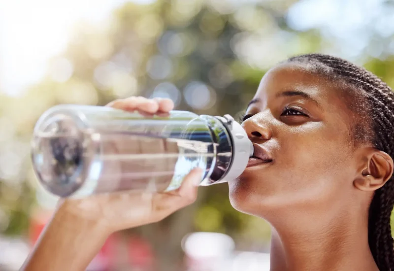 Fitness girl drink bottle of water to refresh after sports exercise, marathon training run or cardi