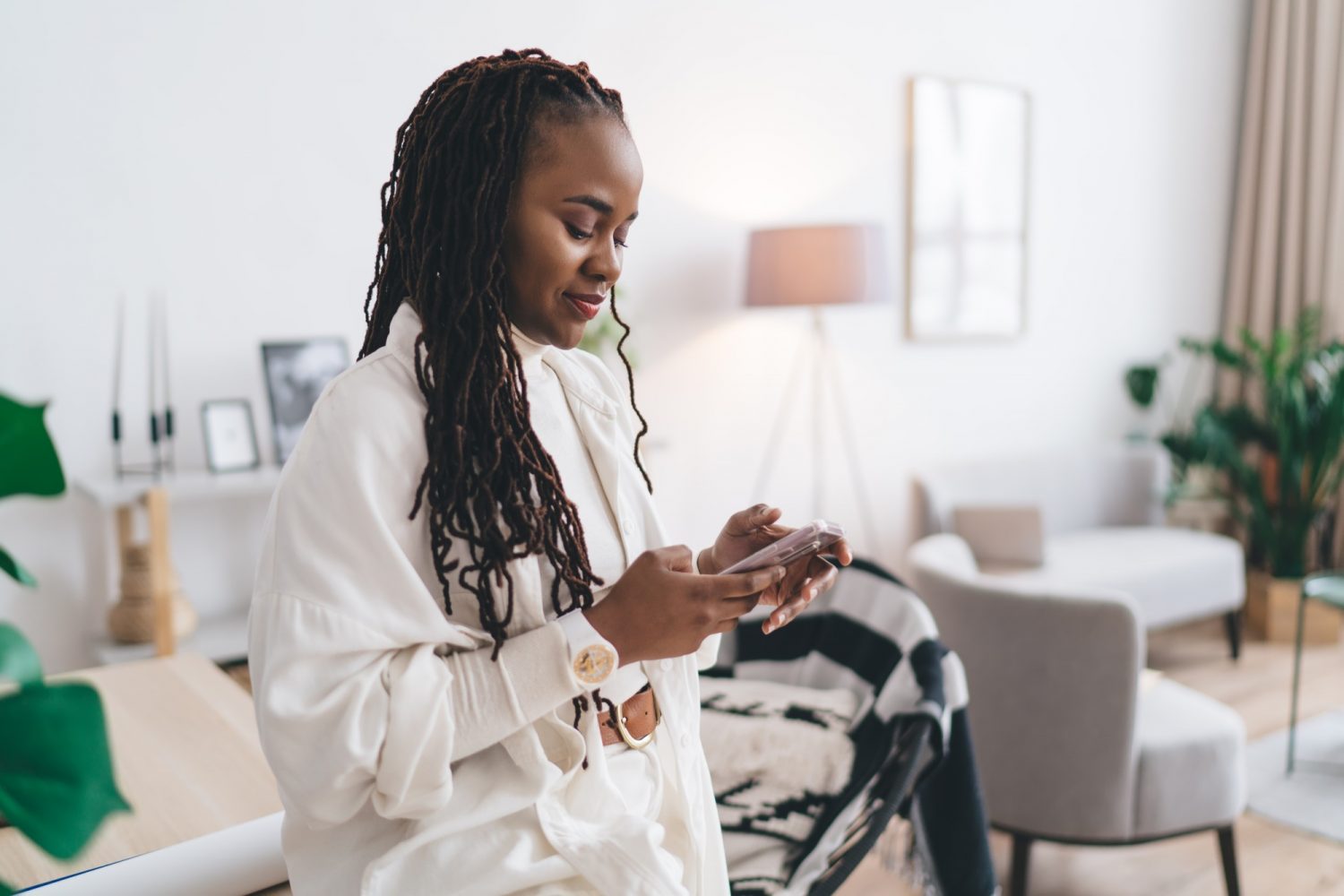 Happy black woman using smartphone in studio
