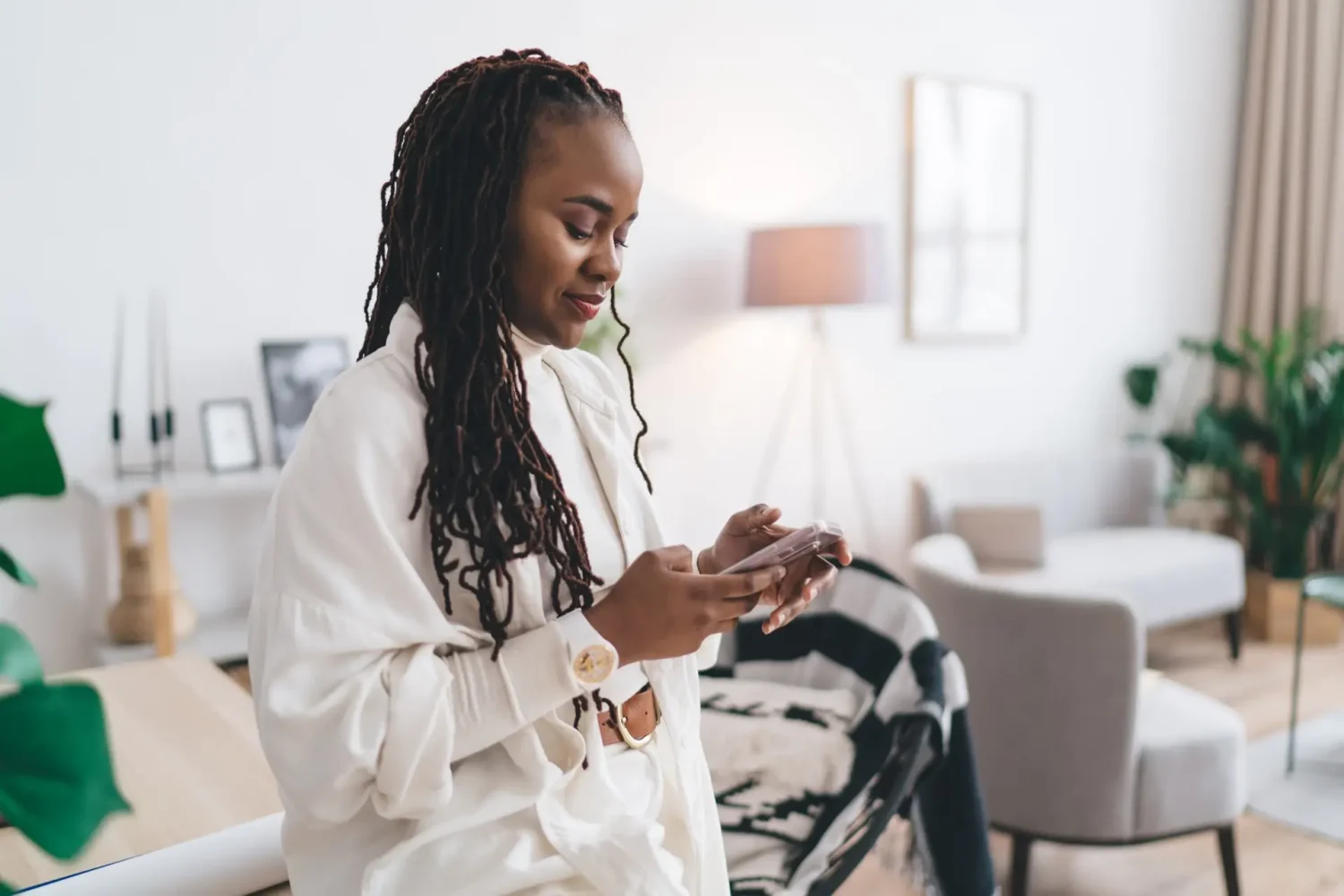 Happy black woman using smartphone in studio