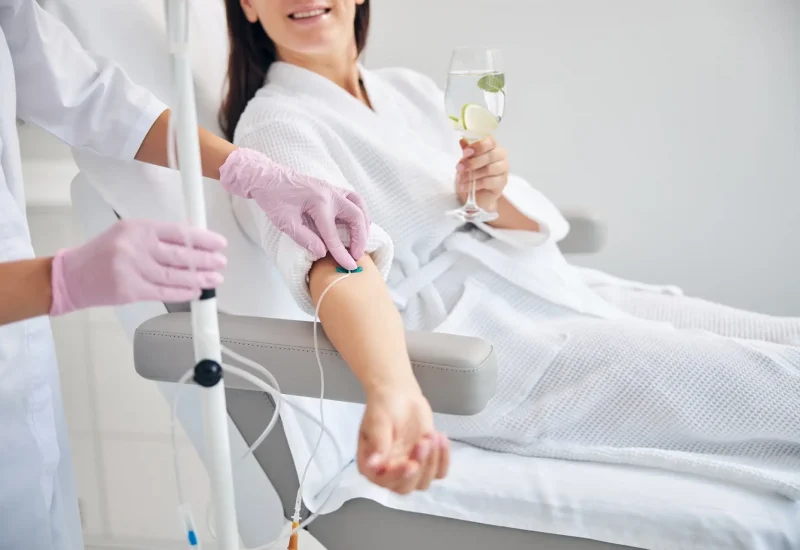 Smiling female patient undergoing intravenous vitamin therapy